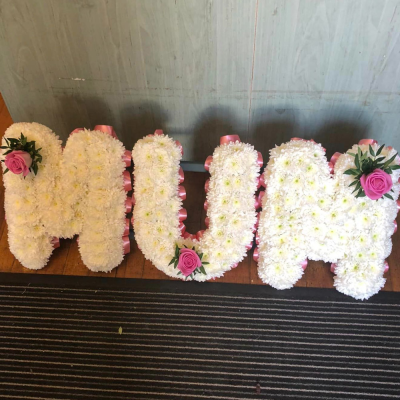 MUM Floral Tribute - A beautiful MUM floral tribute, crafted with white chrysanthemums and accented with pink roses. A loving memorial piece.